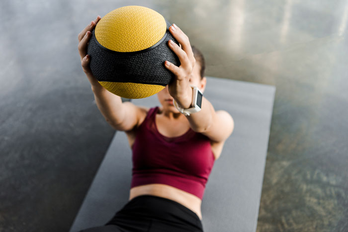woman doing exercise with medicine ball