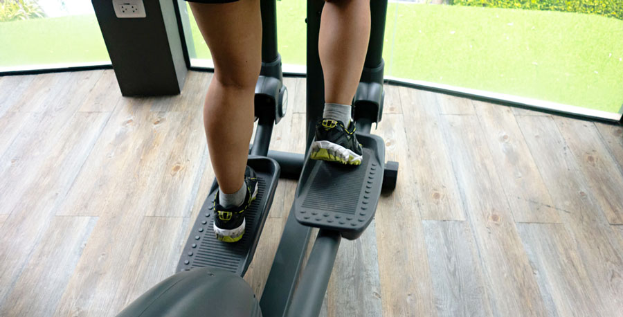 female legs using an elliptical cross trainer